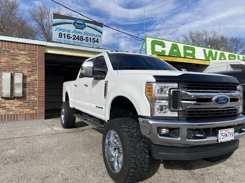 Lifted white pickup truck with mirror-gloss paint after a full detail