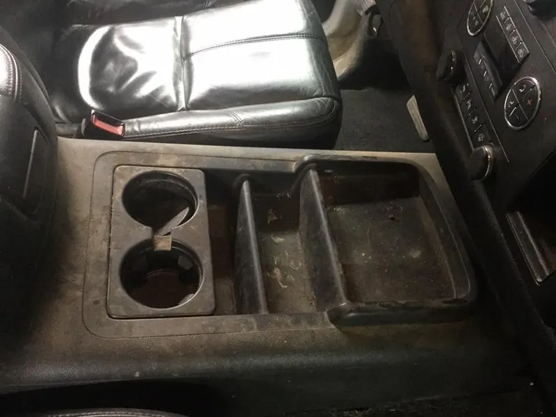 Black pickup-truck interior — deep-clean detail (center-console cup holders)